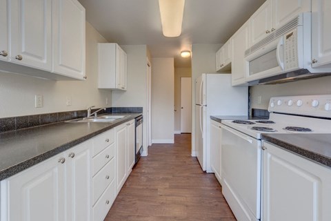 a kitchen with white cabinets and white appliances